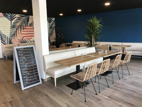 Une banquette élégante et des sièges en rotin modernes pour ce restaurant