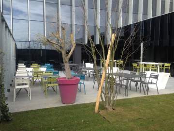 Un extérieur design : chaises et tables tout en métal de plusieurs couleurs pour apporter de la gaîté