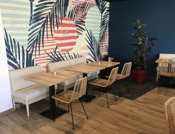 De jolies banquettes pour accompagner ces chaises en rotin qui se fondent parfaitement dans le décor