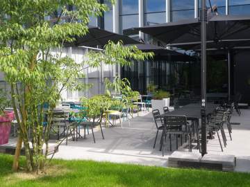 Quelques parasols, des chaises et tables en métal et en couleur, un extérieur qui a du style