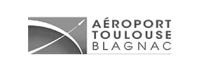 Logo Aéroport Toulouse Blagnac : Graphisme Aérien Logo de l'Aéroport Toulouse Blagnac : un symbole stylisé d'ailes en mouvement et le texte AÉROPORT TOULOUSE BLAGNAC.